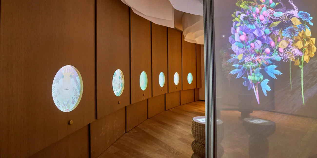 7 Herbs — Poland Pavilion at Expo 2025. MunchingSquare portfolio example of spatial work, not described as an AI-only production. Circular displays in a wood-lined gallery beside a vivid digital flower arrangement at Poland’s Expo 2025 pavilion.